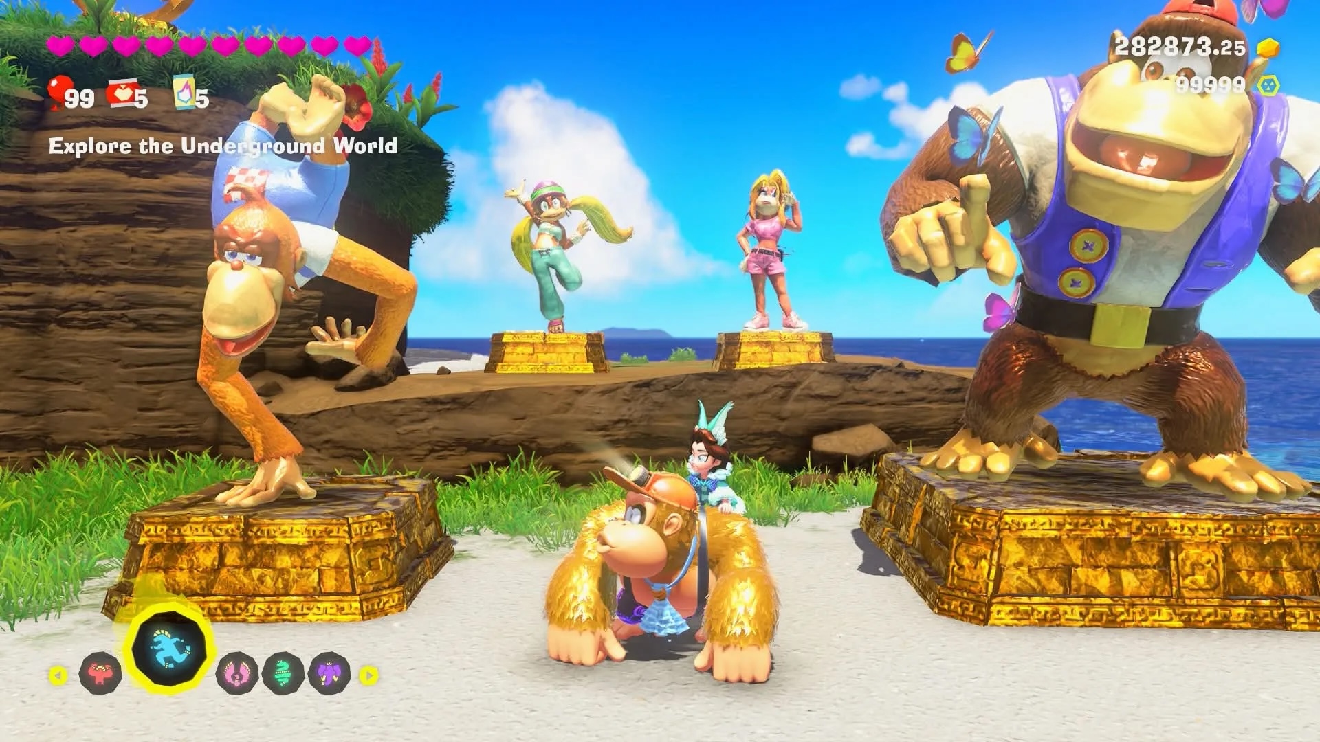 DK & Pauline stand in front of statues of Lanky Kong, Tiny Kong, Candy Kong and Chunky Kong on DK Island in Donkey Kong Bananza